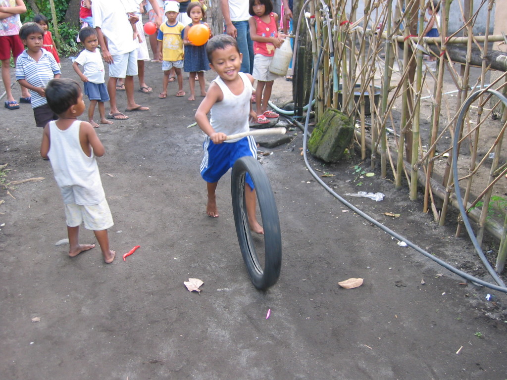 Children playing with the wheel of motor bike