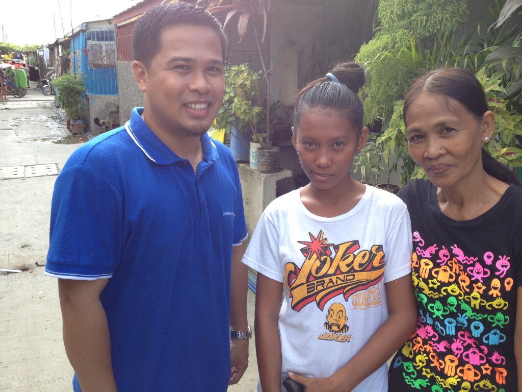 Sherwin with a sponsored child and her mother, during a community visit
