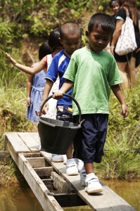 Kids from Baan Tharn Namchai helping out at the rubber plantation