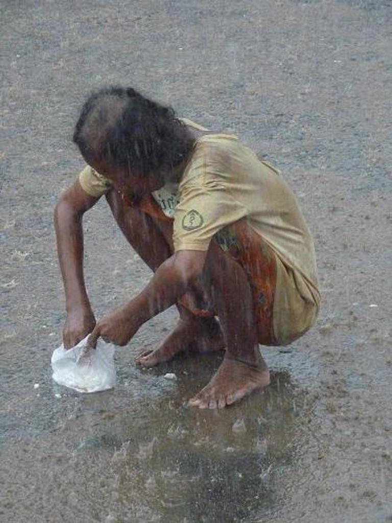 This man earns money by squatting in the middle of the road eating rice so the buses have to stop and pay him before he moves on...very clever!